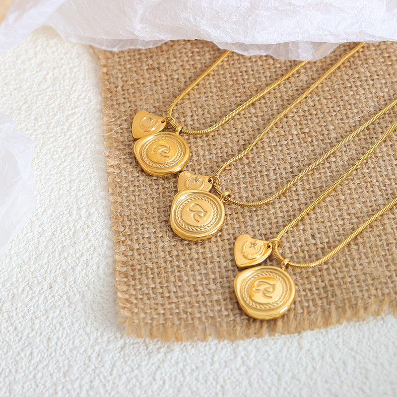 Einfache, runde, gravierte Buchstaben-Halskette, mit Sternen und Monddesign aus 18 Karat vergoldetem Edelstahl.